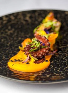 Tentacles of an octopus on a mango puree, Stock Photos