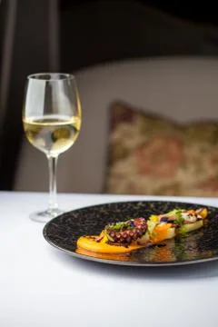 Tentacles of an octopus on a mango puree, restaurant serving of a dish. Stock Photos