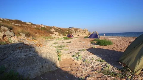 Tents under wind on wild sandy seashore Stock Footage 79543803
