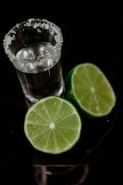 Tequila with lime on black background Stock Photos