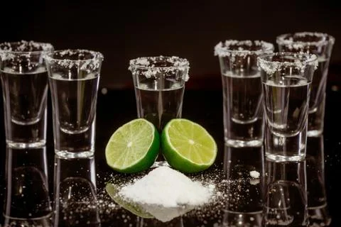 Tequila with lime on black background Stock Photos