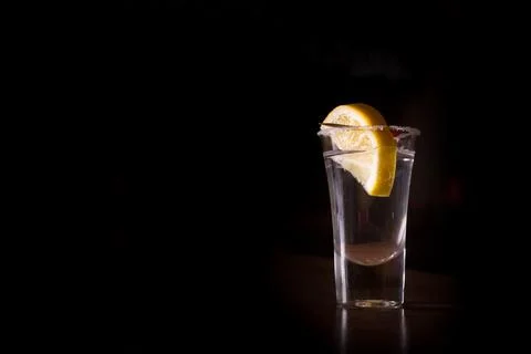 Tequila shot with lemon on the dark background. Shallow DOF Stock Photos