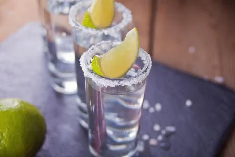Tequila shot with lime and sea salt on black tray, selective focus Stock-Fotos