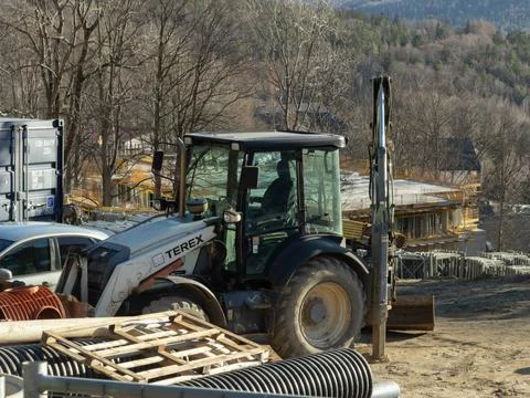Terex backhoe loader parked at an active building site with industrial Stock Photos