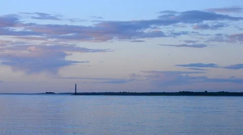 Tern flies at sunset with beautiful clouds and lighthouse Stock Footage 51425238