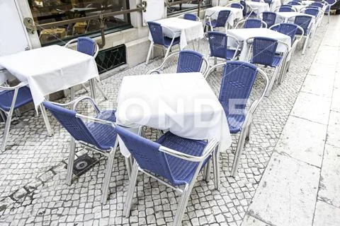 Terrace of a bar on the street, detail of a few tables and chairs Stock Photos
