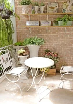 Terrace or balcony with small table, chair and flowers Stock Photos