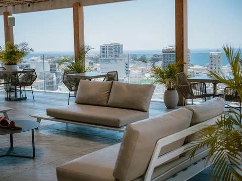 Terrace relaxation area with sofas and ocean city view Stock Photos