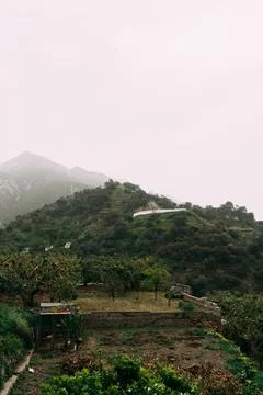 Terraced fields and sparse homes dot the verdant slopes of Spain's mountains Stock Photos