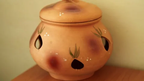 A terracotta ceramic storage pot with a lid and holes. Stock Footage 341242966