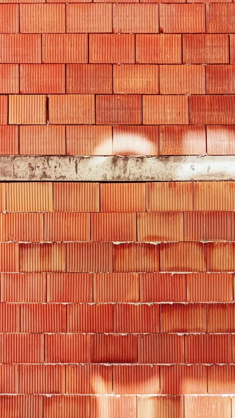 Terracotta tiles create an interesting pattern of shadows on a wall in a bright Stock Footage 340156044