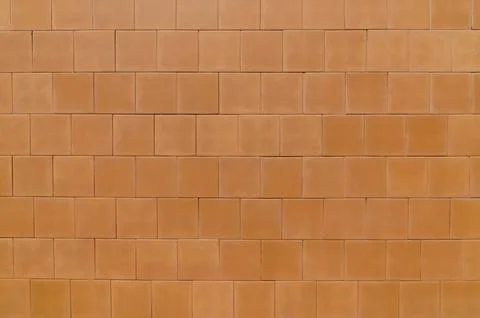 Terracotta tiles forming uniform rectangular wall pattern in full frame Stock Photos
