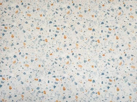 Terrazzo pattern with blue and orange stone chips on a light cream plaster wall. Stock Photos