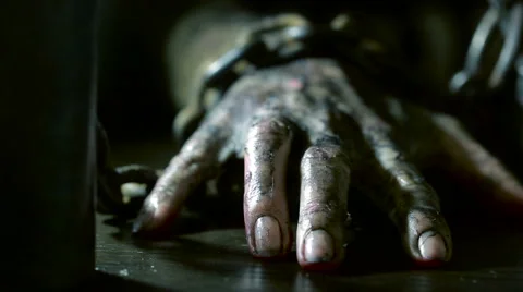 Terrible burnt hand is chained to an iron chain. monster hand on Halloween Stock Footage
