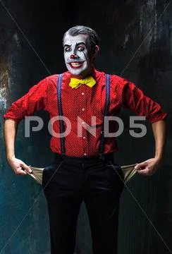 Terrible clown and Halloween theme: Crazy red clown in a shirt with suspenders Stock Photos