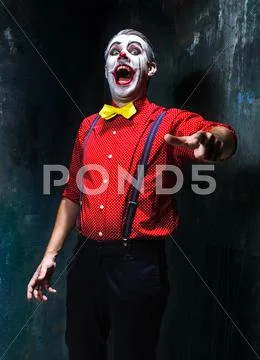 Terrible clown and Halloween theme: Crazy red clown in a shirt with suspenders Stock Photos