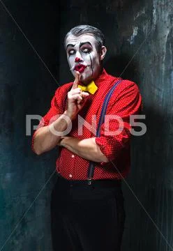 Terrible clown and Halloween theme: Crazy red clown in a shirt with suspenders Stock Photos