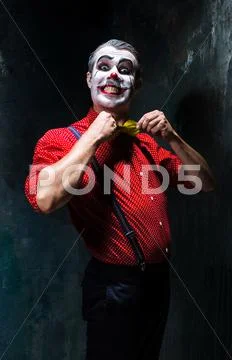 Terrible clown and Halloween theme: Crazy red clown in a shirt with suspenders Stock Photos
