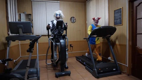 Terrible clowns exercise on modern treadmill elliptical Stock Footage 113080256