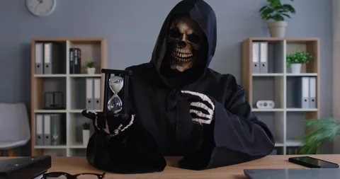 Terrible grim reaper, skeleton or devil in black costume posing at office desk Stock Footage 320264842