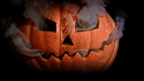 A terrible Halloween pumpkin burns with hellfire. Smoke from the eyes, fire  Stock Footage 116889058