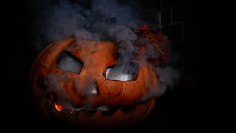 A terrible Halloween pumpkin burns with hellfire. Smoke from the eyes, fire Stock Footage 116893721