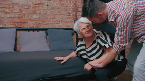 Terrified grandmother having a panic attack held by her caucasian middle-aged Stock Footage 170464967