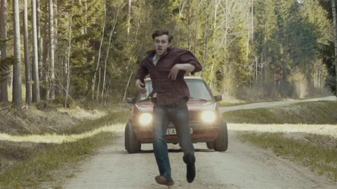 Terrified man escapes in slow motion from the chasing car Stock Footage 81362052