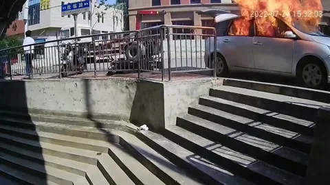 Terrified man flees as car explodes next to him in China Stock Footage 272885333