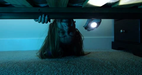 Terrified woman in bed looking beneath Stock Footage 196136557