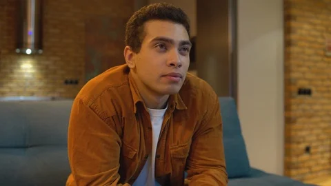 Terrified young man jumping away from tv, shocked by program, leisure at home 스톡 동영상 124588762