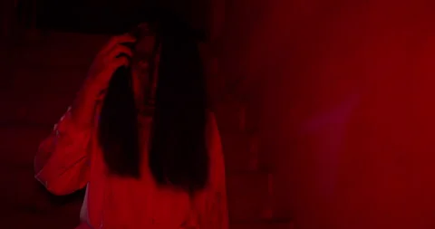 Terrifying female ghost emerges from the shadows of a dark Stock Footage 344374124