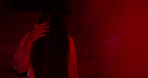 Terrifying female ghost emerges from the shadows of a dark Stock Footage 344374147