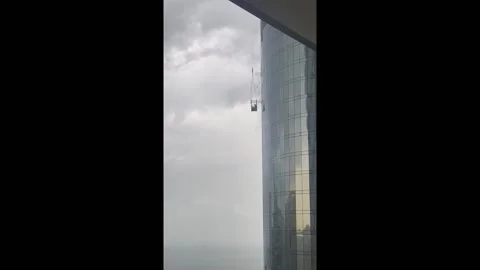 Terrifying storm swings construction worker into skyscraper in Dubai, UAE Stock Footage 254423430
