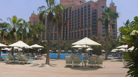 The territory by the pool with blue water with sun beds in Dubai Stock Footage 246089395