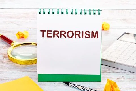TERRORISM text on the white sheet of the notebook is next to a magnifying gla Stock Illustration