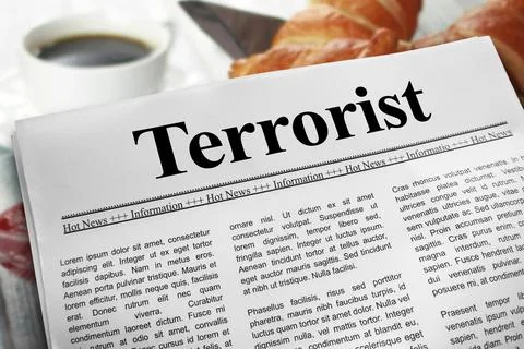 Terrorist in newspaper layout on a breakfast table with a blurry cup of cof.. Stock Photos