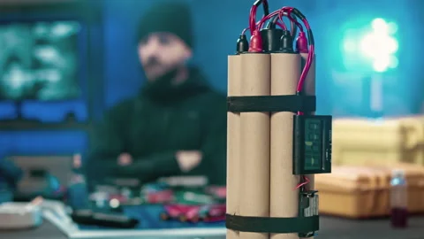 A terrorist out of focus camera is studying the scheme. In the foreground a bomb Stock Footage 121730063