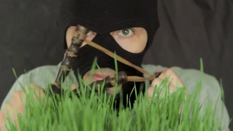 The terrorist Peeps out of the grass and watches Stock Footage 87981312