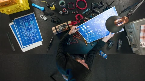 The terrorist is studying a timer, and is holding an electrical circuit. Видео 97686903