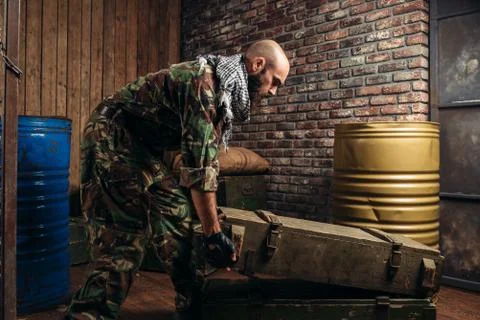 Terrorist in uniform loads boxes of ammunition Stock-Fotos