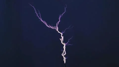 Tesla coil generating high voltage electricity showing a vibrant purple spark Stock Photos