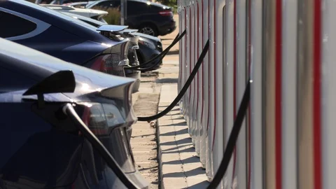 Tesla electric car charging station with cars recharging their batteries Stock Footage