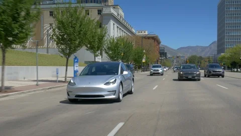Tesla Model 3 drives through traffic in downtown Stock-Footage 93419970