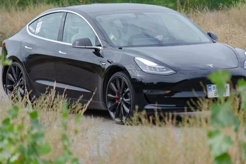 Tesla model 3 spacex edition. Black electric sports car drives at high speed  Stock Photos