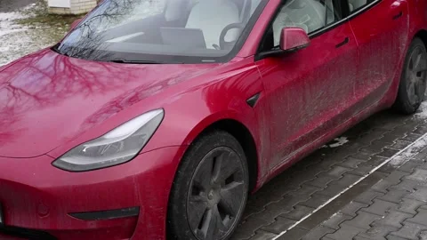 Tesla model S car being charged with a yellow mussle car in background Stock Footage 169163474