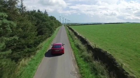 Tesla Model S driving in front of wind urbines Video stock 80651125