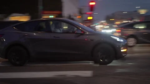 Tesla Model Y car driving amidst city traffic by the intersection of Melrose Ave Stock Footage 269635899
