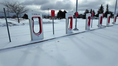 Tesla Superchargers array standing in winter, enabling electric vehicle travel Stock-Footage 335937664