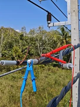 Test clips connected to stripped high voltage underground cable conductor . Stock Photos